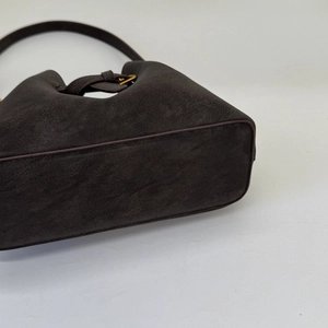 Detailed base of dark brown suede bucket bag featuring premium stitching and flat bottom