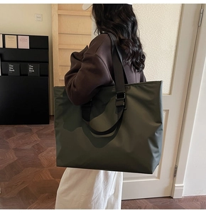 Sac fourre-tout en nylon vert olive porté à l'épaule dans un intérieur moderne