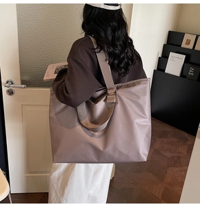 Vue de dos d'un mannequin portant un grand sac cabas en nylon mauve dans une pièce épurée