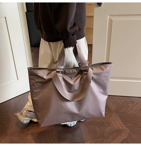 Détail du sac cabas en nylon rose poudré avec large poignée tissée et coutures de qualité