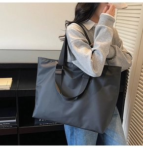Vue détaillée du grand sac cabas noir en nylon avec de larges bandoulières et fini mat