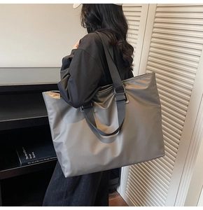Détail du sac fourre-tout en nylon taupe avec large bandoulière en tissu réglable