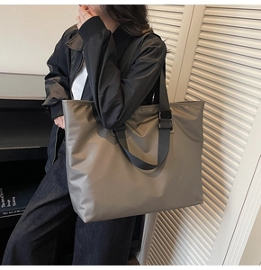 Vue latérale d'un grand sac cabas en nylon taupe porté par un mannequin en intérieur
