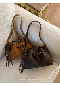 Detailed view of vintage leather bucket bags with heart tassel charms and strap buckles