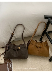 Detail view of retro brown half-moon bucket bags with gold buckles and heart charms