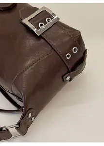 Detailansicht der silbernen Gürtelschnalle und Ösen an der dunkelbraunen Vintage-Tasche