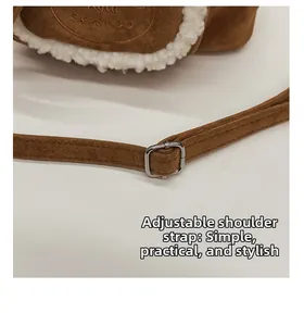 Close-up of adjustable brown suede shoulder strap with silver metal buckle on bucket bag