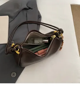 Vista superior del interior espacioso del bolso de cuero café oscuro con detalles dorados