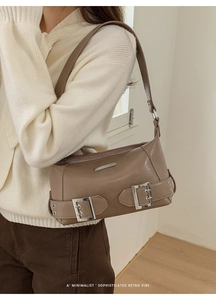 Braune Vintage-Unterarmtasche kombiniert mit minimalistischem Outfit in moderner Umgebung