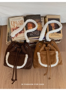 Detail of suede bucket bags in brown and camel with white faux shearling trim accents