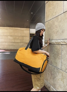 Detalle de bolsa de viaje amarilla con tela impermeable y compartimento para zapatos