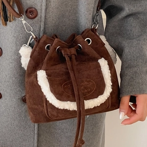 Brown faux suede bucket bag with white fleece trim and drawstring closure