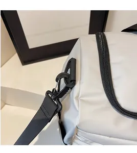 Detail eines hochfesten Nylon-Schultergurts mit einem stabilen Metallkarabiner an einer Reisetasche