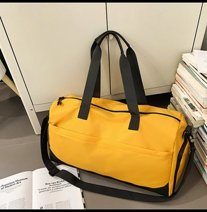 Detalle de bolsa de deporte en nailon amarillo con correas negras y compartimento seco