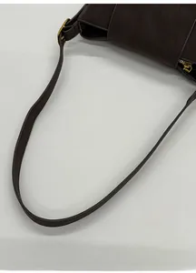 Détail de la bandoulière en cuir marron foncé avec boucle métallique dorée chic