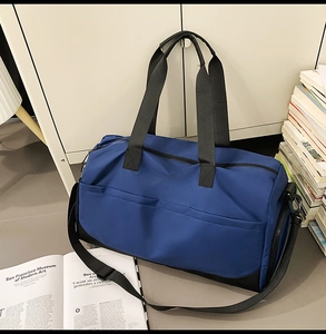 Detalle del bolso de viaje de nailon impermeable azul y negro con asas dobles y bandolera