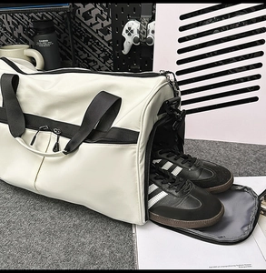 Detalle del compartimento para zapatos en el bolso deportivo blanco y negro