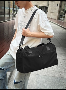 Bolsa de deporte negra impermeable de gran capacidad llevada como bandolera en la calle