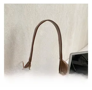 Detail van een warmbruine gewatteerde leren schoudertas met een comfortabel rond handvat