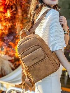 Minimalist brown vintage PU leather backpack for women shown in a scenic autumn setting