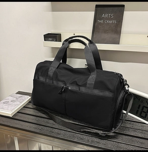 Detalle de bolsa deportiva de nailon negro con asas reforzadas y correa ajustable