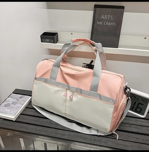 Detalle lateral de la bolsa de deporte rosa y beige con compartimento para calzado