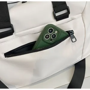 Detail view of side zipper pocket on travel bag showing space for a smartphone