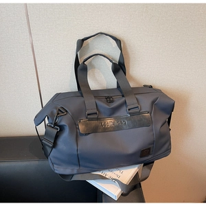 Detail view of water-resistant navy travel bag with leather logo strap and metal clips