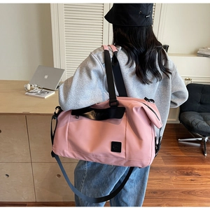 Pink large capacity travel bag with dry wet separation shown on shoulder in home setting