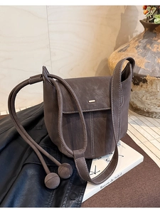 Détail du sac seau gris anthracite avec coutures contrastées blanches et perles décoratives