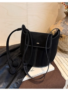 Détail du sac seau en daim noir avec surpiqûres blanches et fermoir en métal doré