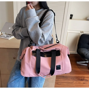 Pink large travel bag detail with durable handles and adjustable shoulder strap