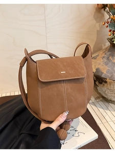 Détail du sac seau marron avec coutures contrastées blanches et fermoir métallique