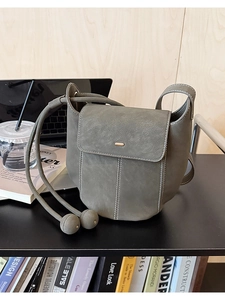 Détails de la besace vert-gris en cuir synthétique avec coutures blanches et fermoir doré