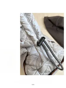 Close-up of quilted down fabric detail with adjustable woven drawstring and plastic buckle