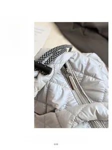 Detail view of the silver quilted tote bag with smooth metal zipper and woven drawstring