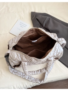 Detailed view of striped inner lining with a zipper pocket in a beige quilted tote bag