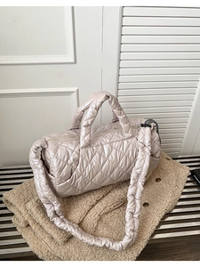 Detail of champagne quilted down tote bag with plush padded straps and silk finish