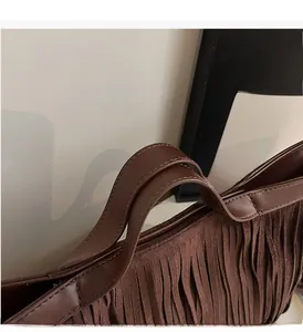 Détail du sac cabas marron foncé à franges montrant la texture suède et les coutures fines