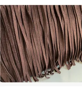 Vue détaillée des franges en daim marron foncé sur un sac cabas vintage chic