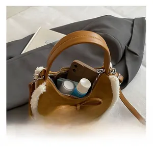 Detail showing the inner capacity of the brown suede handbag with white faux fur trim