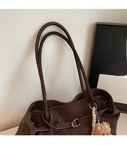 Detail der dunkelbraunen Leder-Tote-Bag mit schmalen Griffen und Streifenfutter