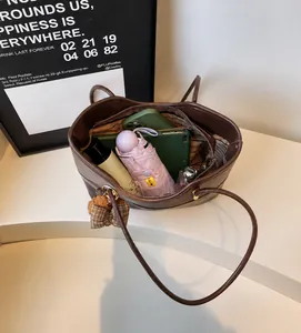 Top view of brown lychee leather tote bag showing spacious interior with teddy bear charm