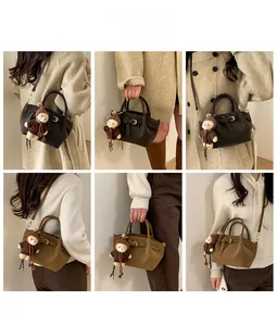 Detail view of retro crossbody bag with adjustable strap and cute plush bear charm accessory