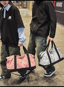 Detalle de bolsa de viaje mostrando texturas onduladas en colores rosa y plata