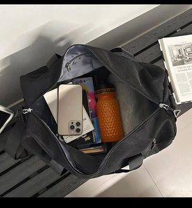 Macro view of spacious black sports gym bag showing internal storage for tablets and books