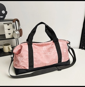 Detalle del bolso de viaje rosa jaspeado con tela impermeable y correa ajustable