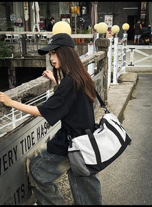 Black and white gym bag with breathable side mesh pocket and adjustable shoulder strap