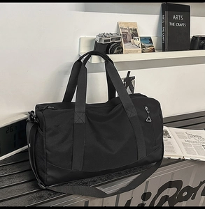 Detail view of the black fitness bag with reinforced handles and durable nylon fabric