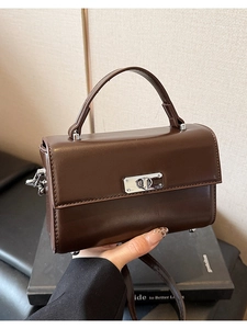 Detail van de vintage bruine vierkante handtas met zilveren draaisluiting en gladde afwerking